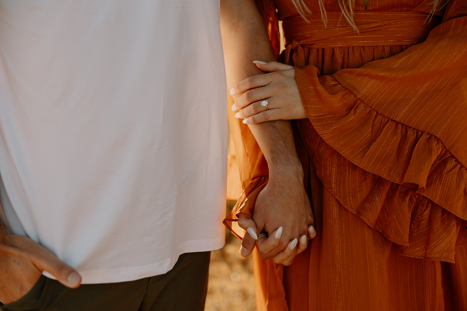Couple holding hands in golden desert light as they elope in Arizona.