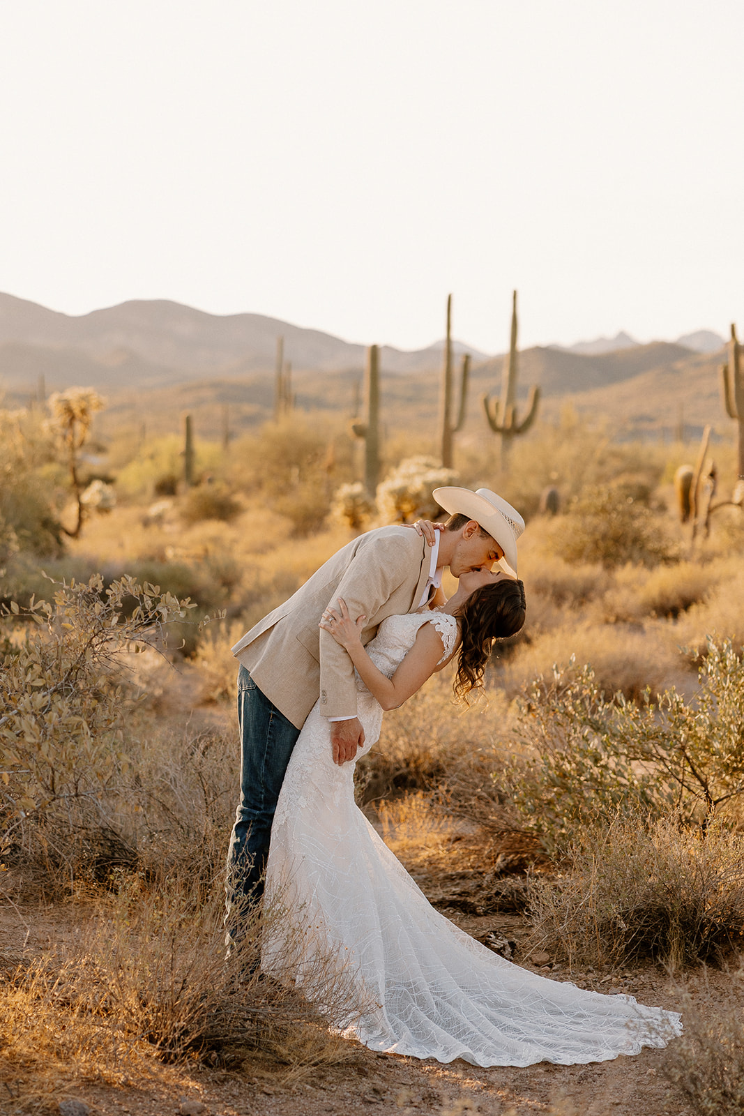 Groom dipping bride for a kiss in the desert as they elope in Arizona.