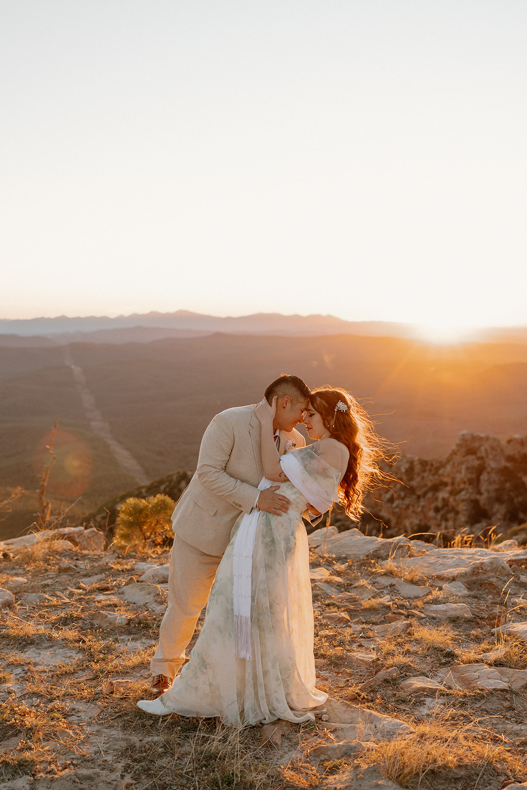 Couple holding hands between tall aspens at sunset after deciding to elope in Arizona.