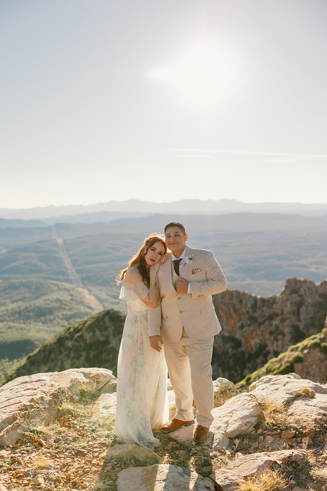 Newly married couple standing together at edge of cliff after they elope to Arizona. 