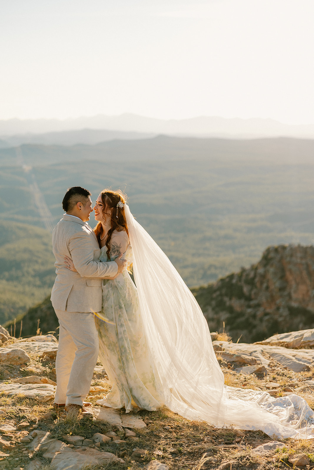 Couple embracing on a rocky cliff during their Arizona elopement at golden hour.