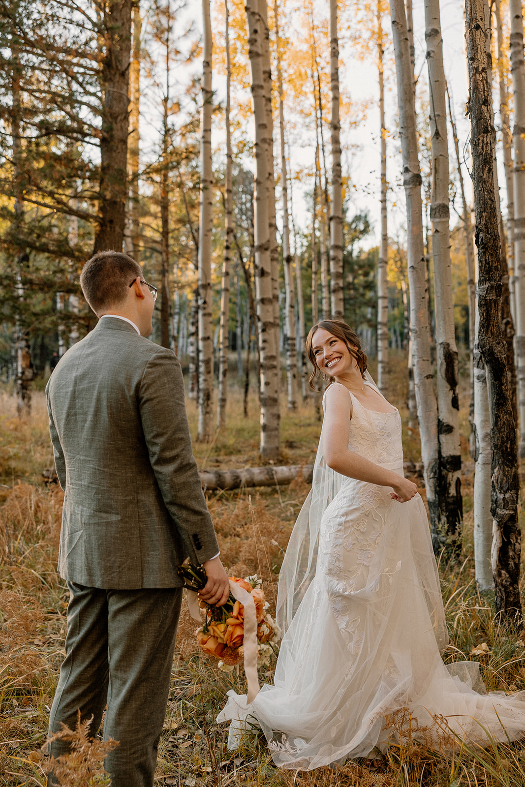 Bride turning back toward groom in a golden aspen forest as they elope in Arizona.