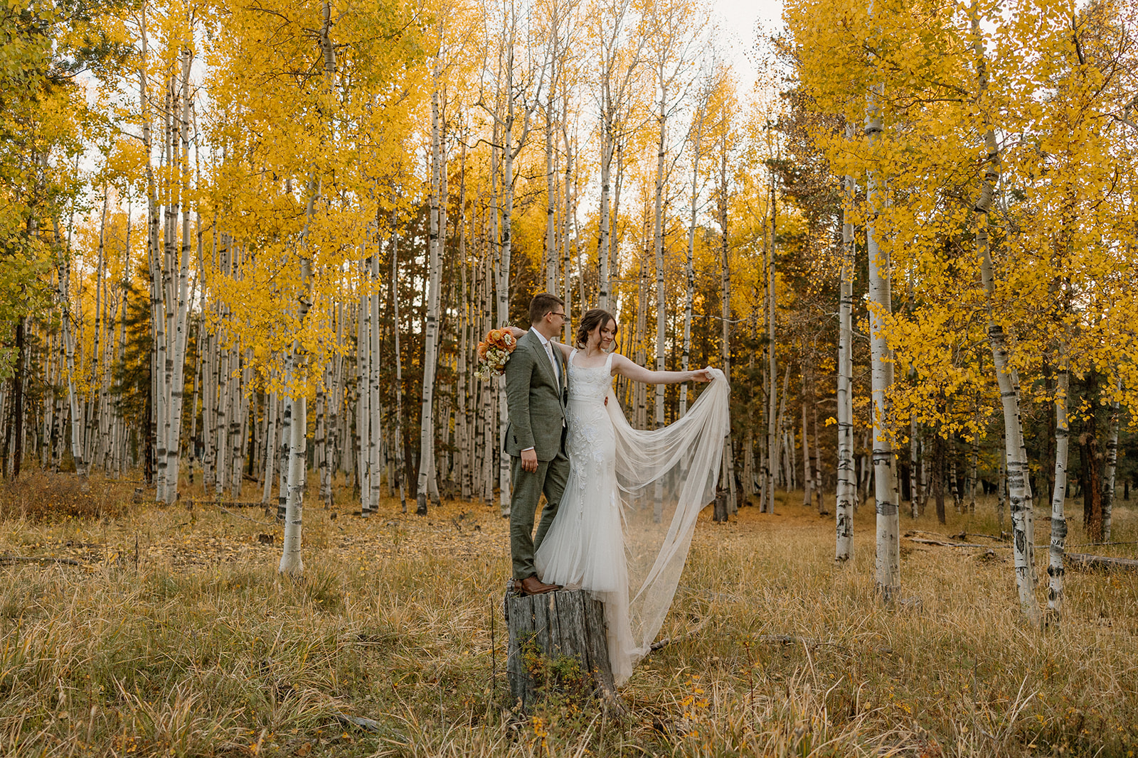 Bride and groom standing in a golden aspen grove during a fall elopement in Arizona.