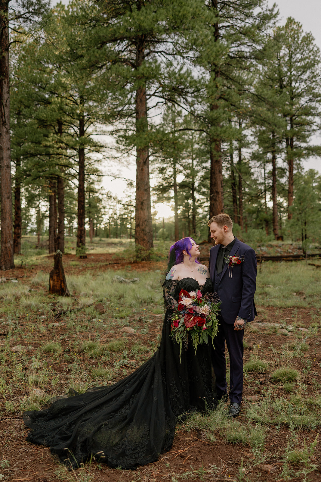 Bride and groom smiling at each other beneath golden fall aspens after they elope in Arizona.