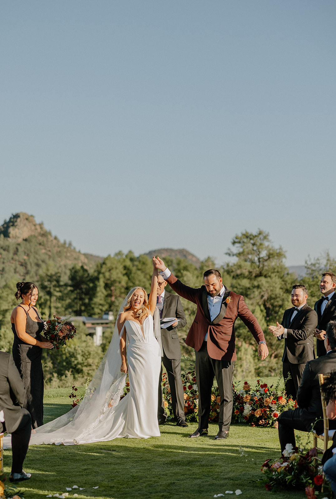 Bride and groom celebrate their ceremony recessional with raised hands and cheers at a Payson wedding venue.