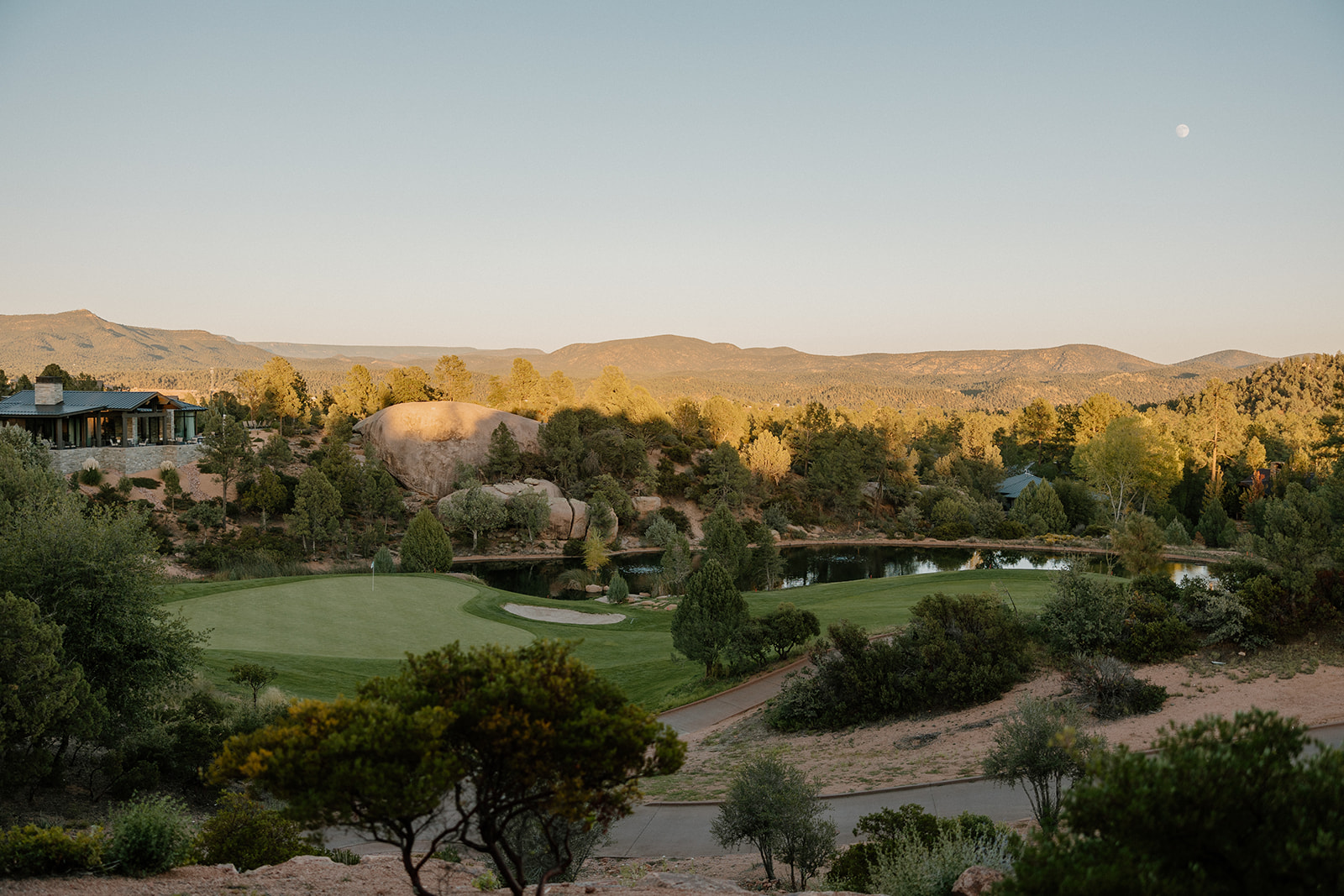 Scenic view of rolling hills, water features, and desert greenery surrounding a Payson wedding venue at golden hour.