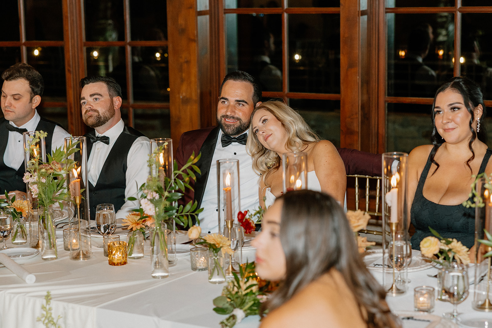 Bride rests her head on the groom’s shoulder during heartfelt toasts inside a Payson wedding venue reception space.