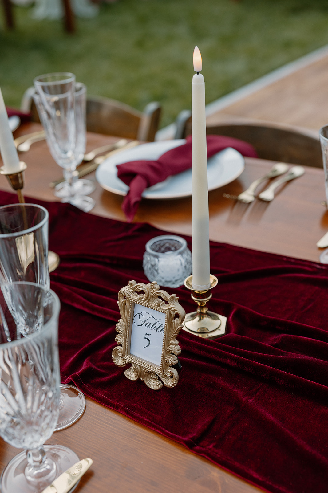 Wedding table detail with burgundy velvet runner, candles, and place setting at an outdoor Sedona wedding