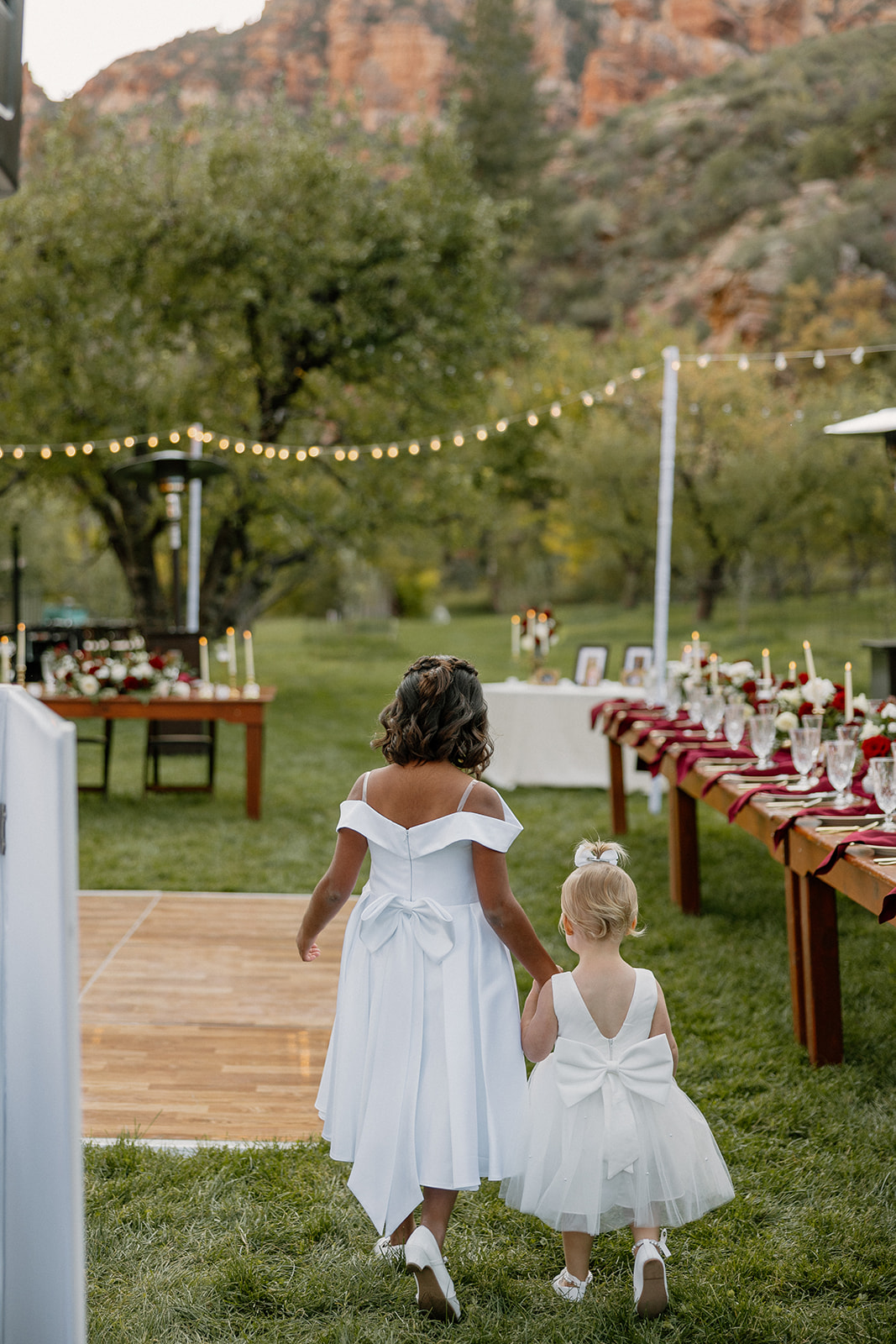 Flower girls walking hand in hand toward the reception at a Sedona wedding venue