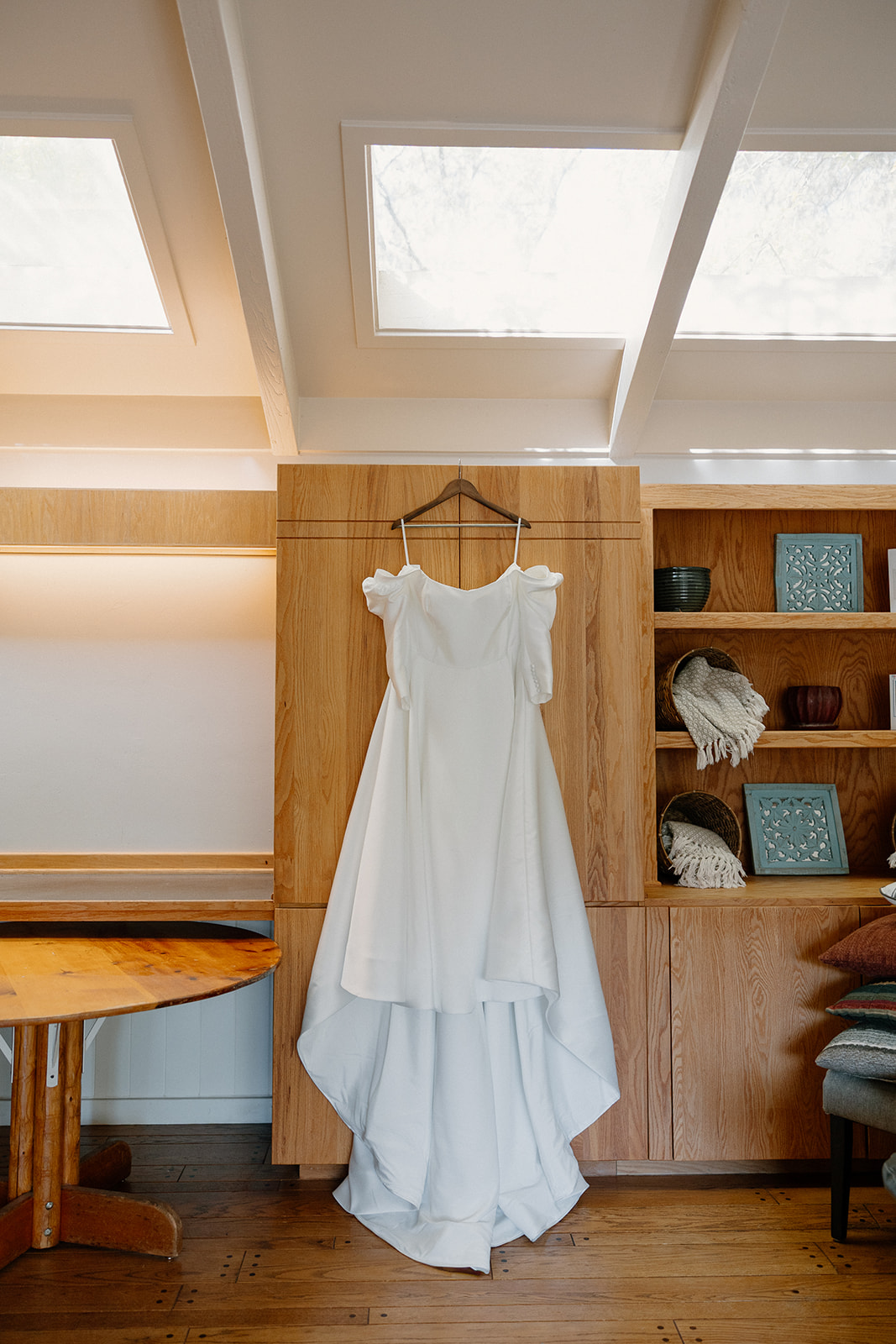 Bride’s wedding dress hanging inside a rustic cabin before the ceremony