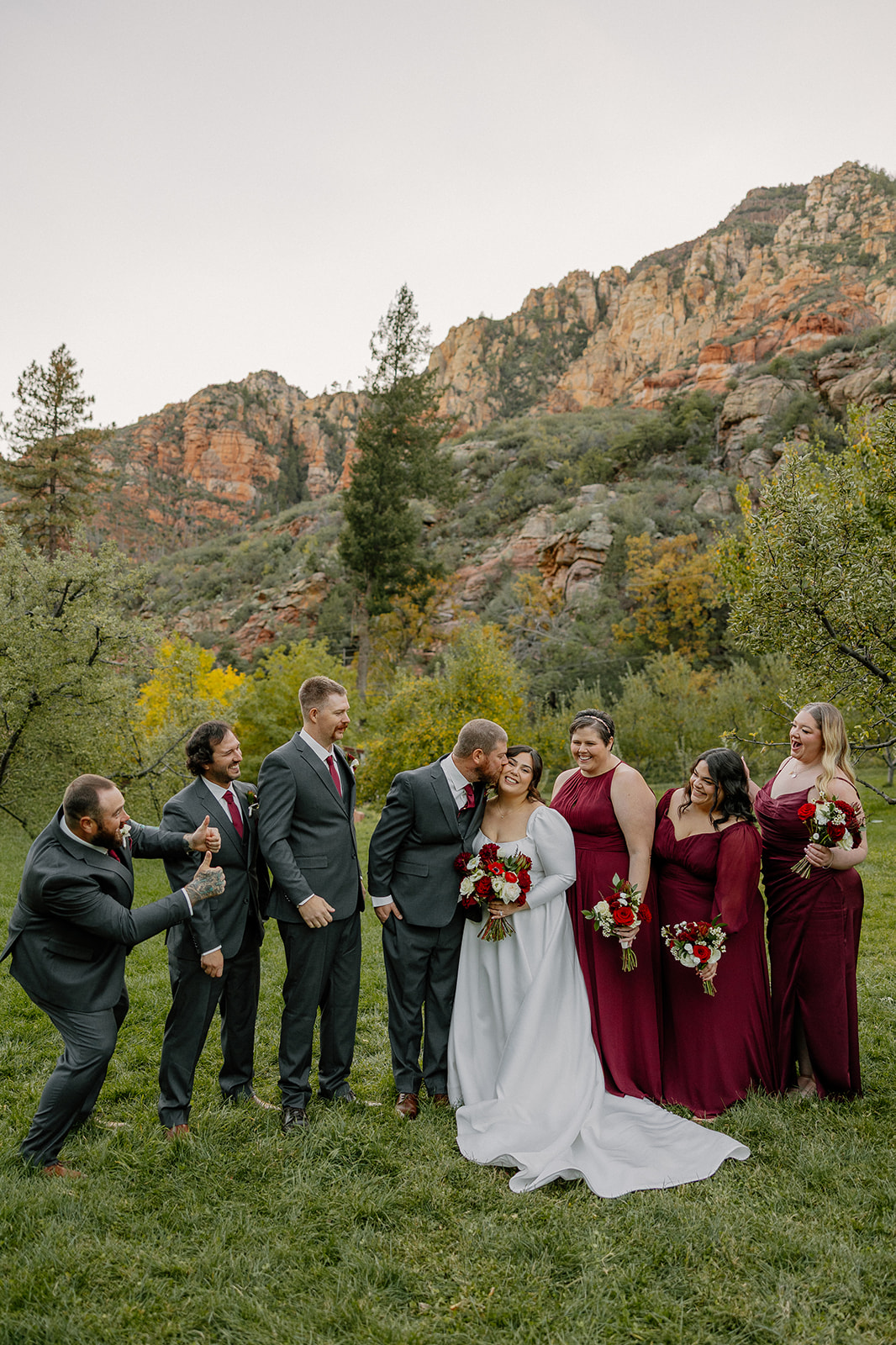 Bride and wedding party laughing together during portraits at an outdoor wedding in Sedona