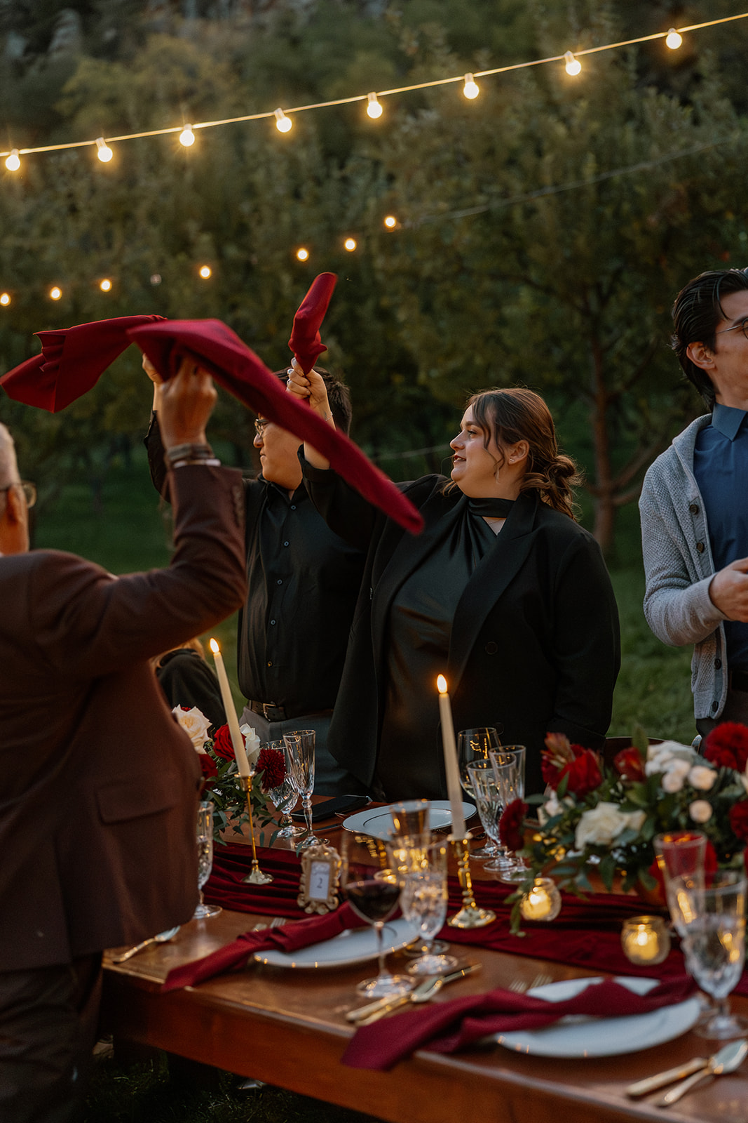 Guests raising napkins and celebrating during dinner at an outdoor wedding reception in Sedona