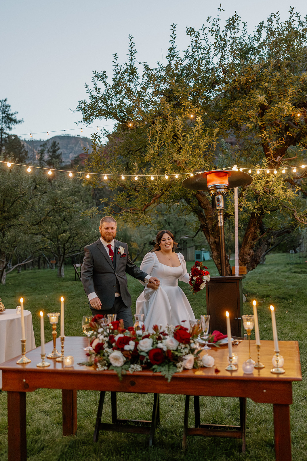 Bride and groom entering their reception at a Sedona wedding venue with string lights and candlelit tables