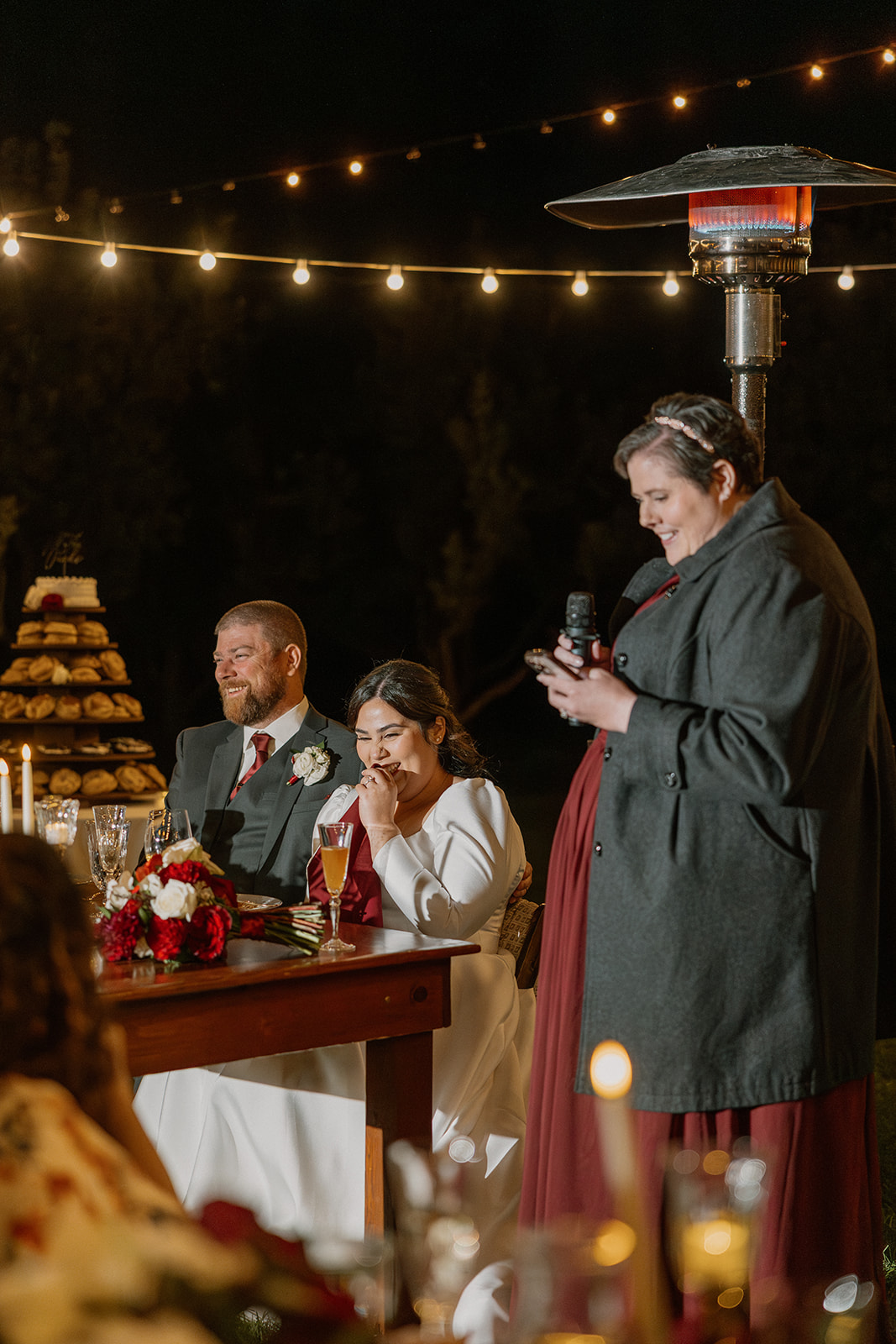 Bride and groom listening to speeches during their outdoor wedding reception at Orchard Canyon on Oak Creek