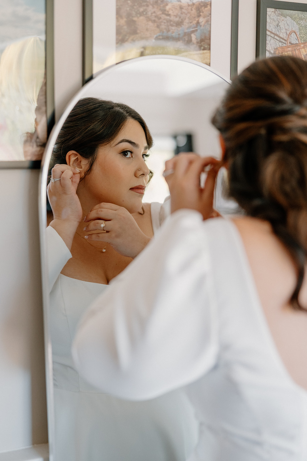 Bride putting on earrings while getting ready inside a cozy cabin at a Sedona wedding venue
