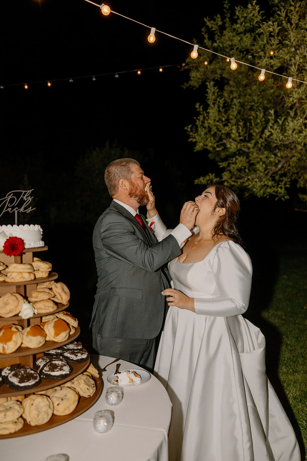 Bride and groom feeding each other dessert during their outdoor Sedona wedding reception