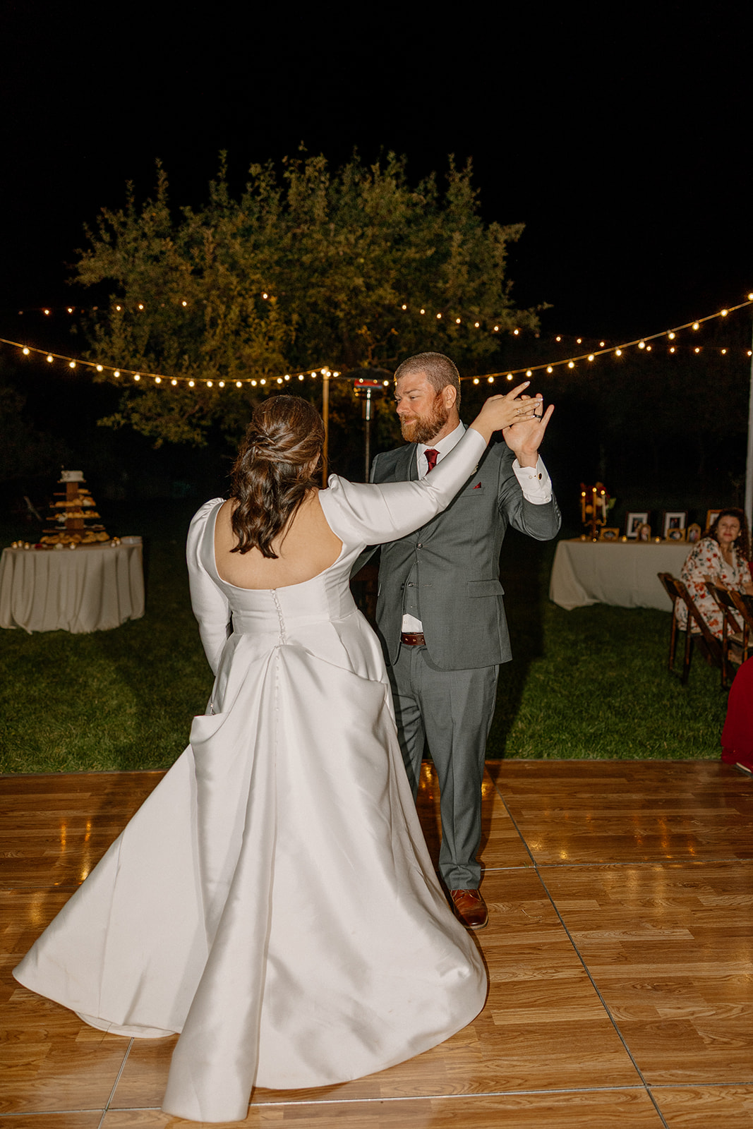Bride and groom sharing their first dance under string lights at a Sedona wedding venue