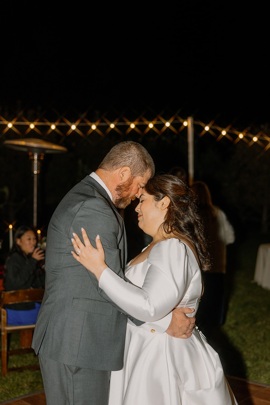 Bride and groom sharing their first dance under string lights at a Sedona wedding venue at night