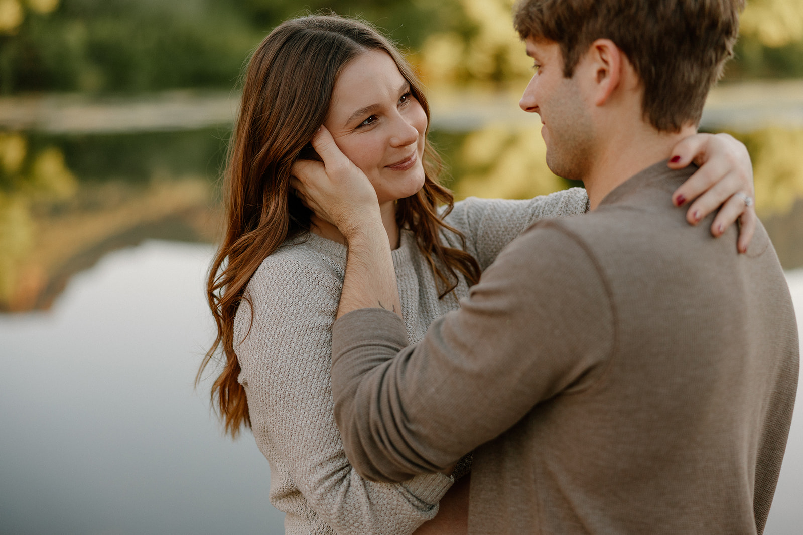 Intimate close-up of couple smiling at each other with soft natural light and shallow depth of field
