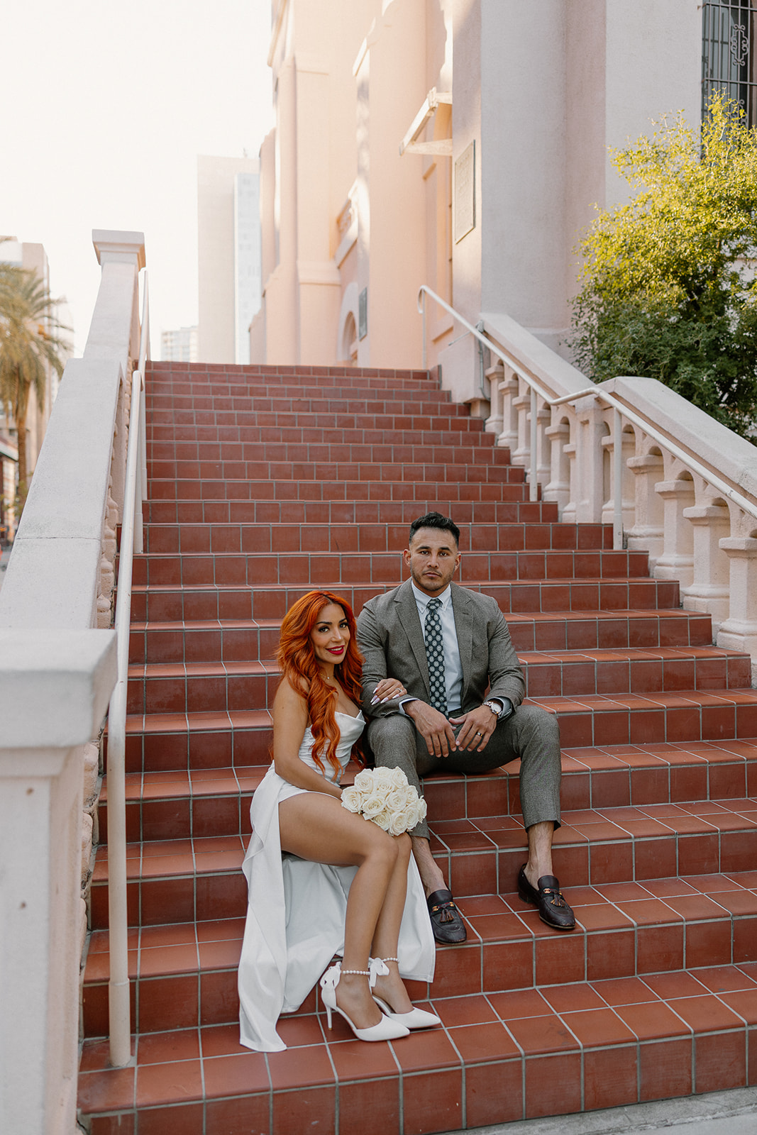 Stylish couple sitting together on wide brick staircase during phoenix engagement photos
