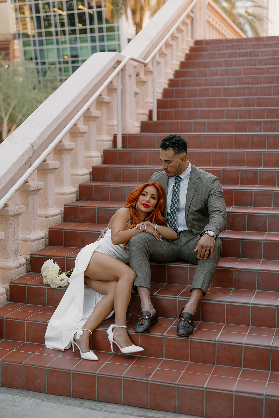 Couple sitting together on terracotta staircase in downtown Phoenix during engagement session
