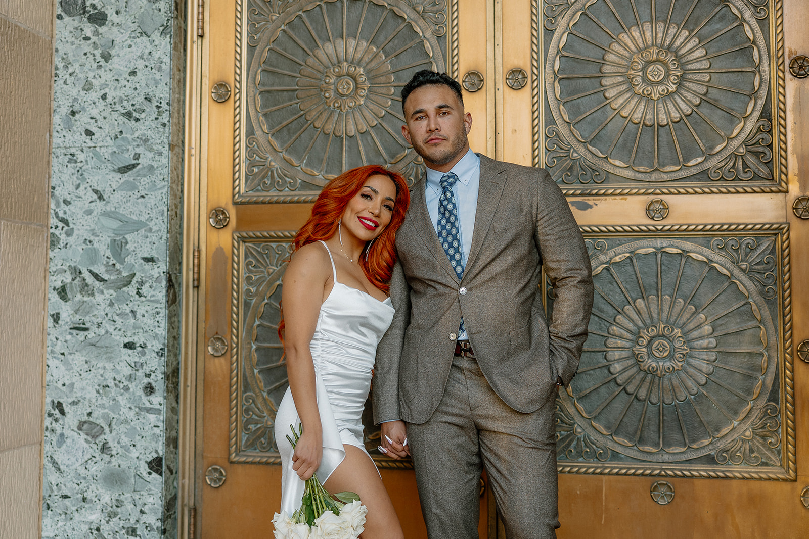 Couple standing together in front of ornate gold doors in downtown Phoenix
