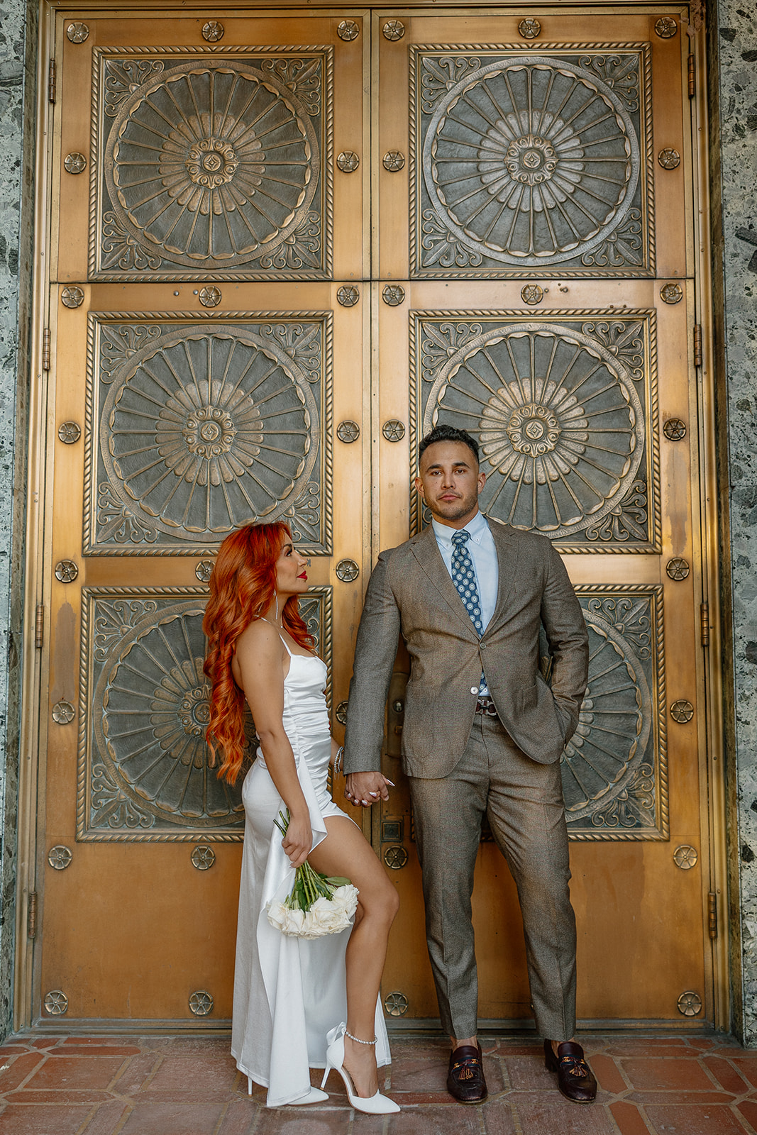 Couple posing together in front of ornate historic doors in downtown Phoenix
