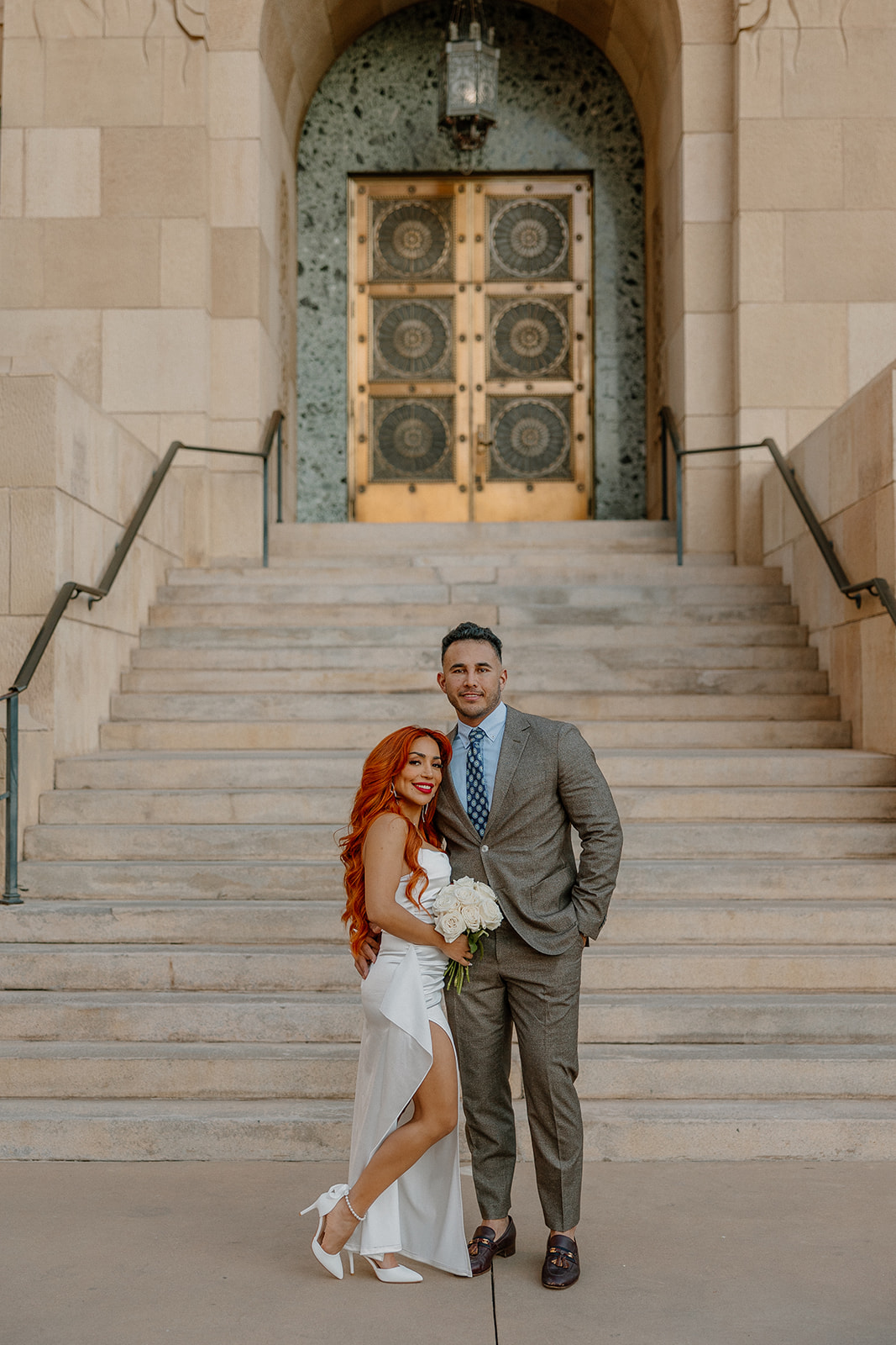 Couple standing together on grand staircase outside historic downtown building for phoenix engagement photos
