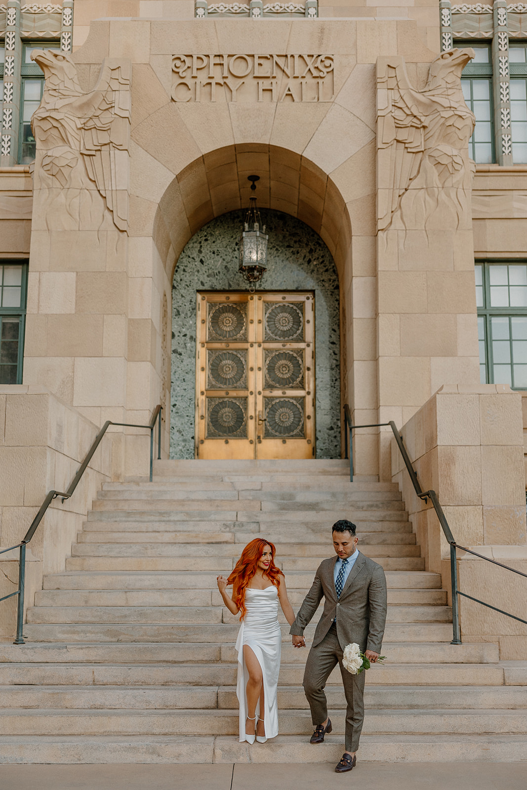 Wide photo of couple outside Phoenix City Hall during phoenix engagement photos
