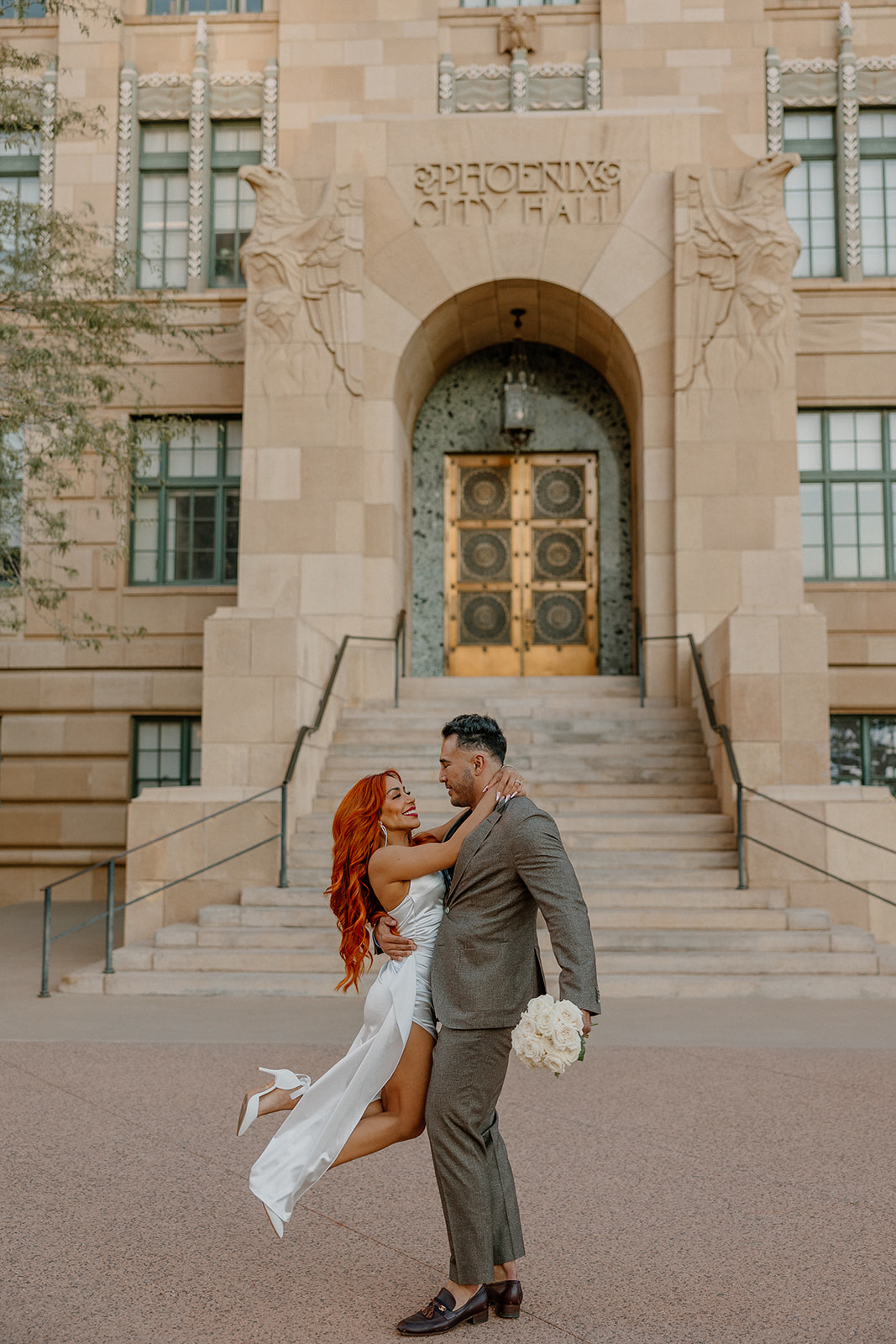 Playful moment in front of Phoenix City Hall during phoenix engagement photos
