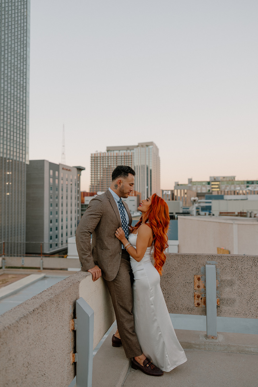 Romantic rooftop portrait with city skyline during phoenix engagement photos
