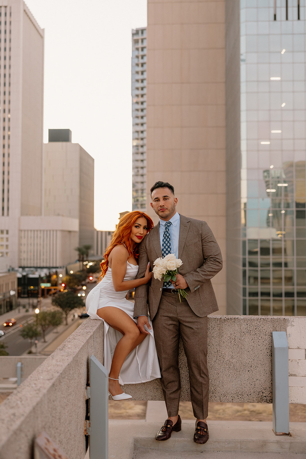 Rooftop portrait of couple with downtown skyline during phoenix engagement photos
