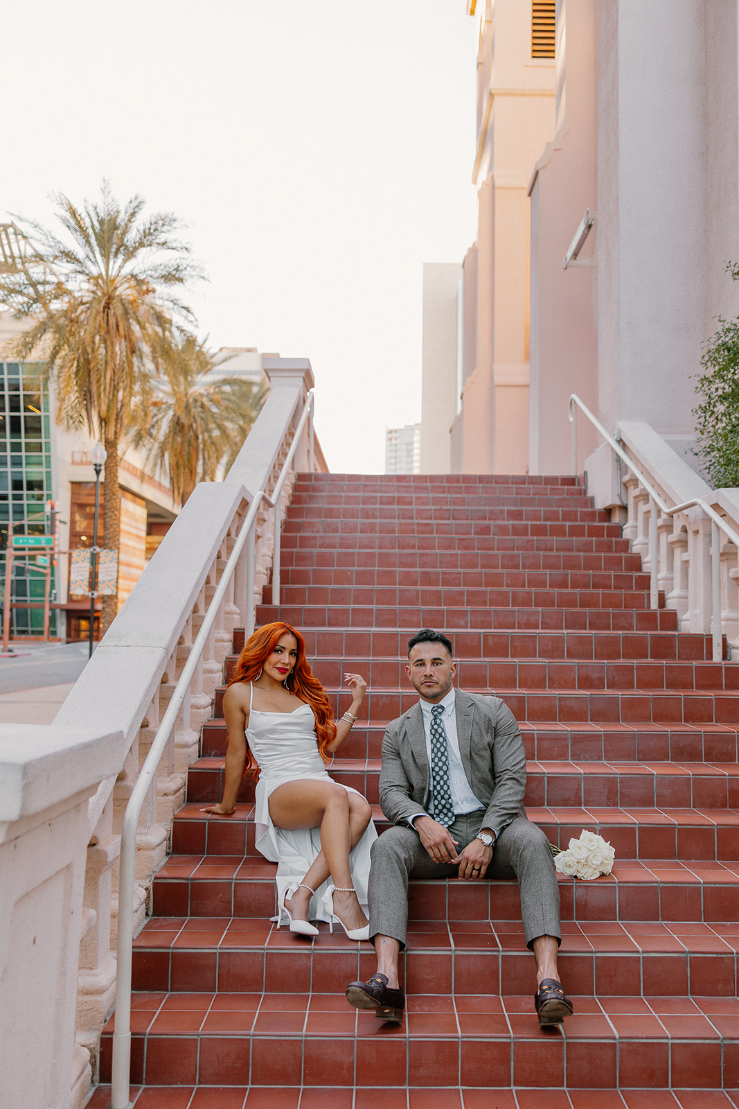 Couple posing on terracotta staircase with historic architecture in downtown Phoenix
