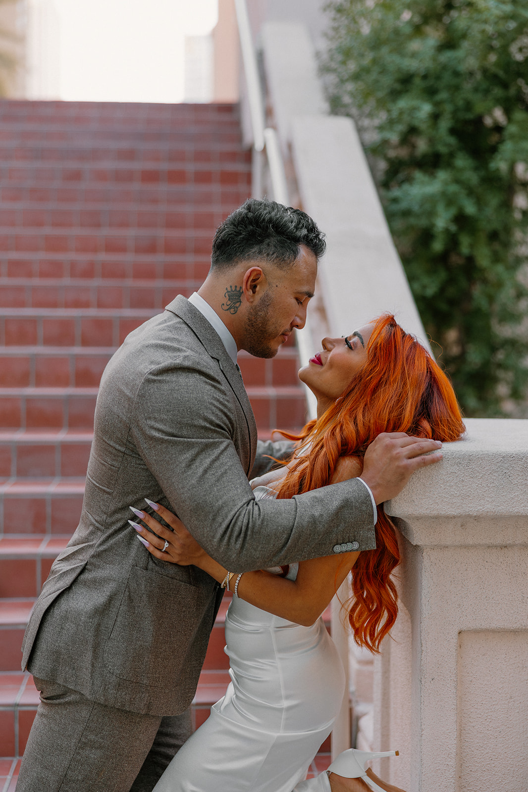 Close romantic moment beside terracotta staircase during downtown Phoenix engagement session
