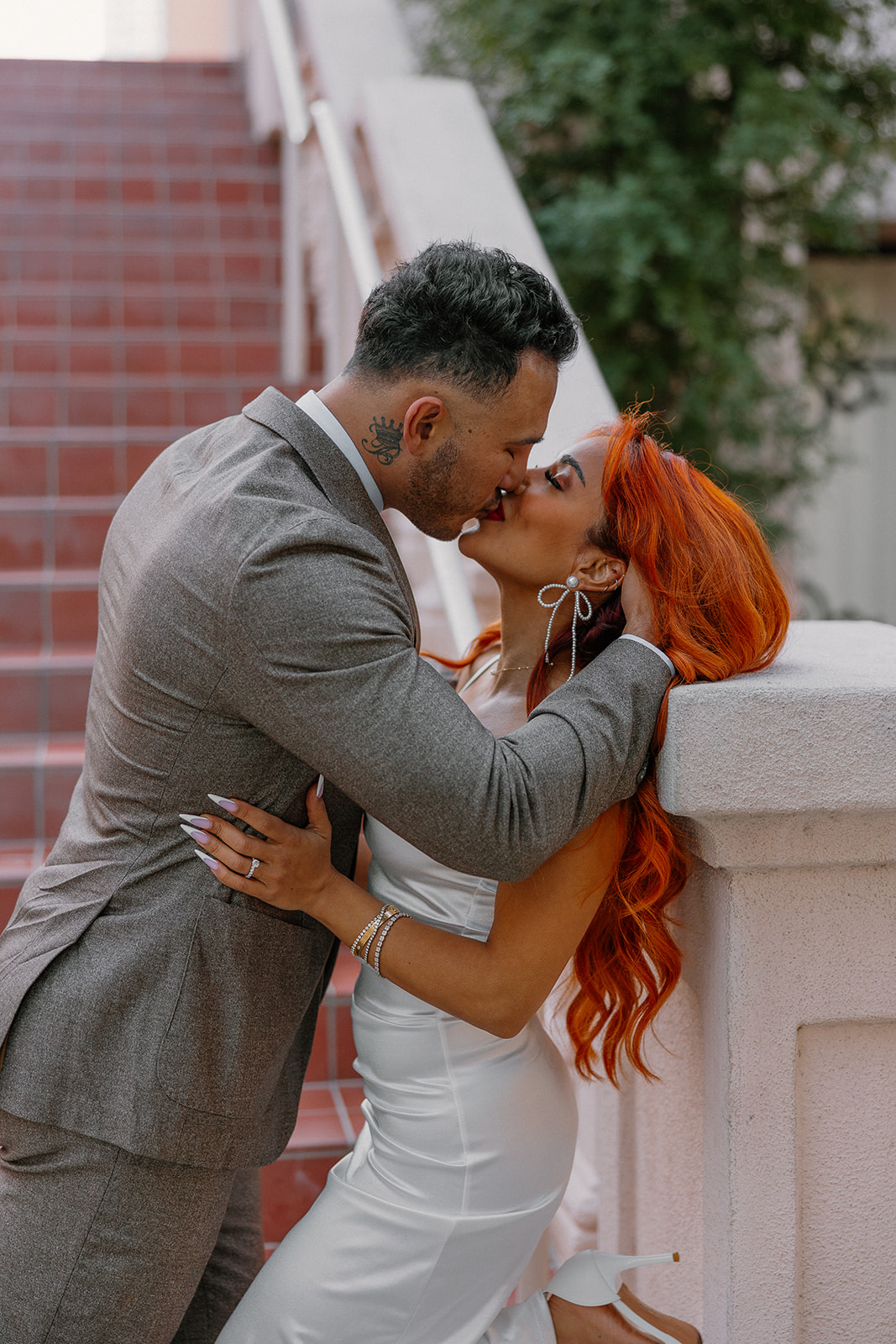 Close-up of couple kissing beside terracotta staircase in downtown Phoenix

