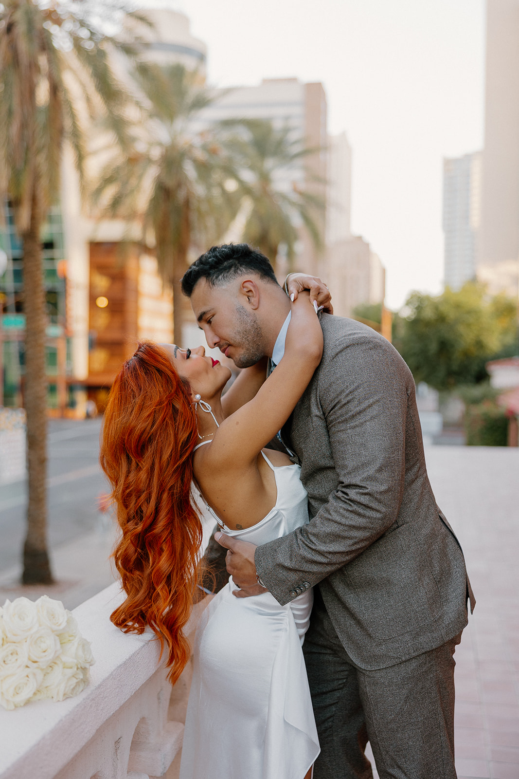 Romantic moment on palm-lined street during phoenix engagement photos in downtown Phoenix
