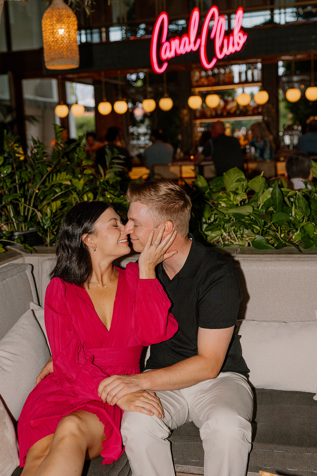Couple kissing on a couch at The Canal Club during hotel engagement photos
