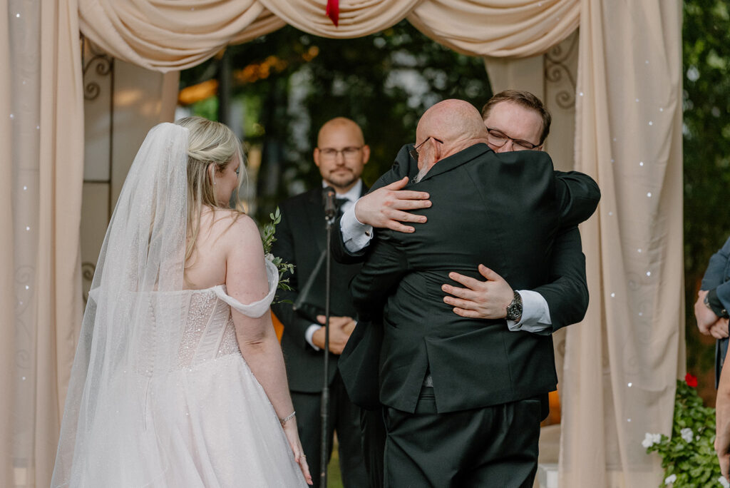 Emotional hug during outdoor ceremony at Stonebridge Manor Wedding Venue in Mesa