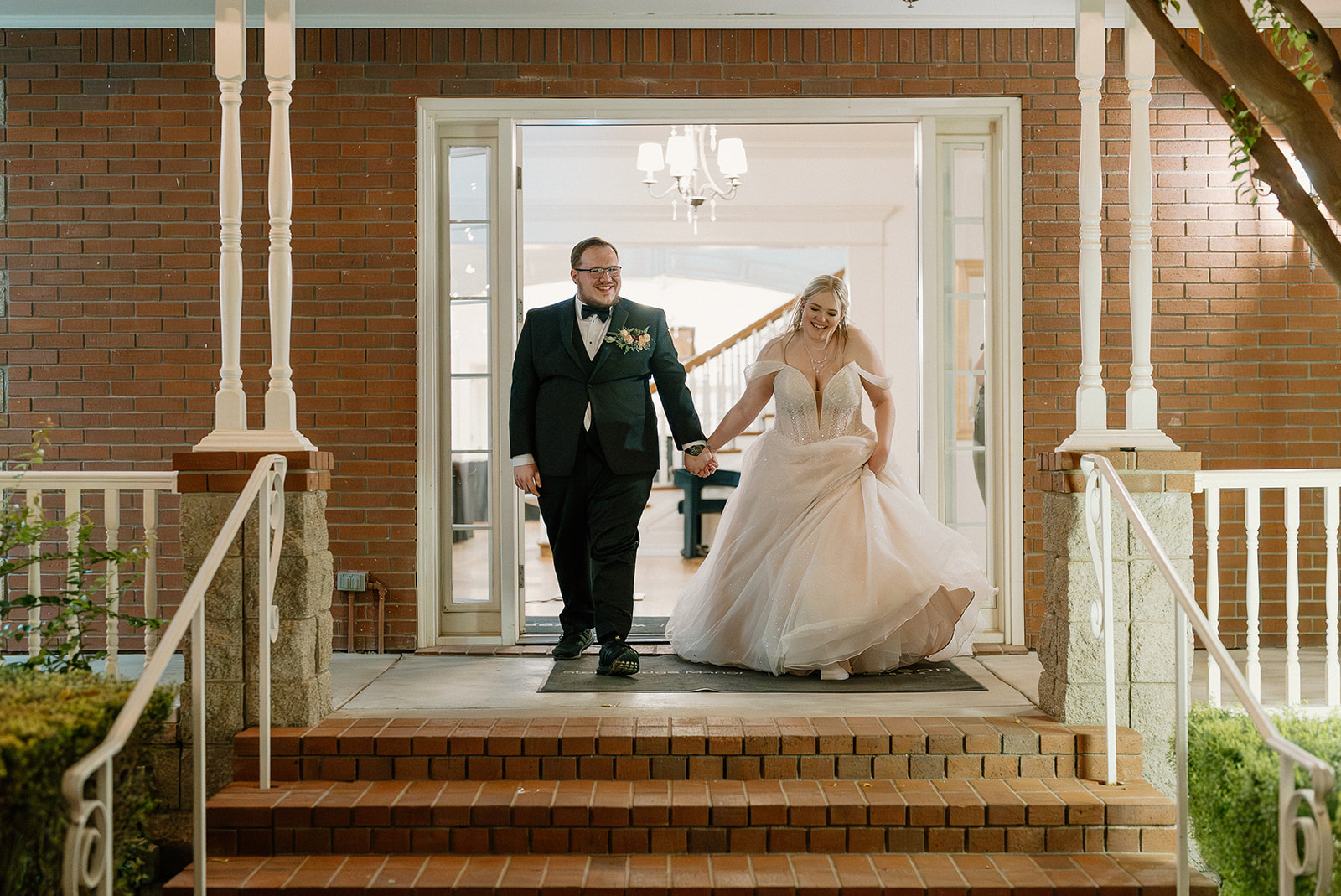 Newlywed couple walking out of the Stonebridge Manor building entrance in Mesa Arizona