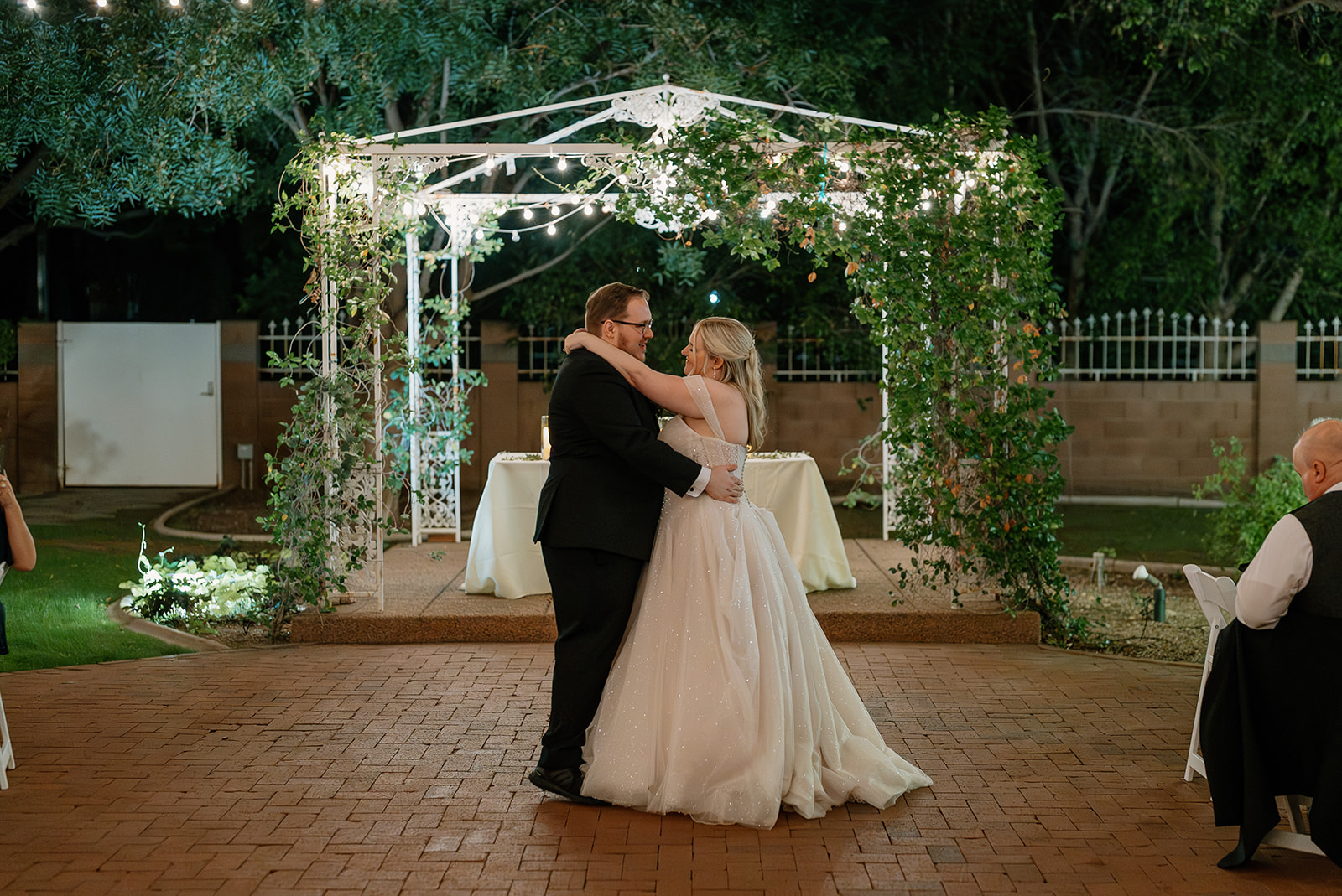 Newlyweds sharing their first dance beneath the gazebo lights at Stonebridge Manor Wedding Venue