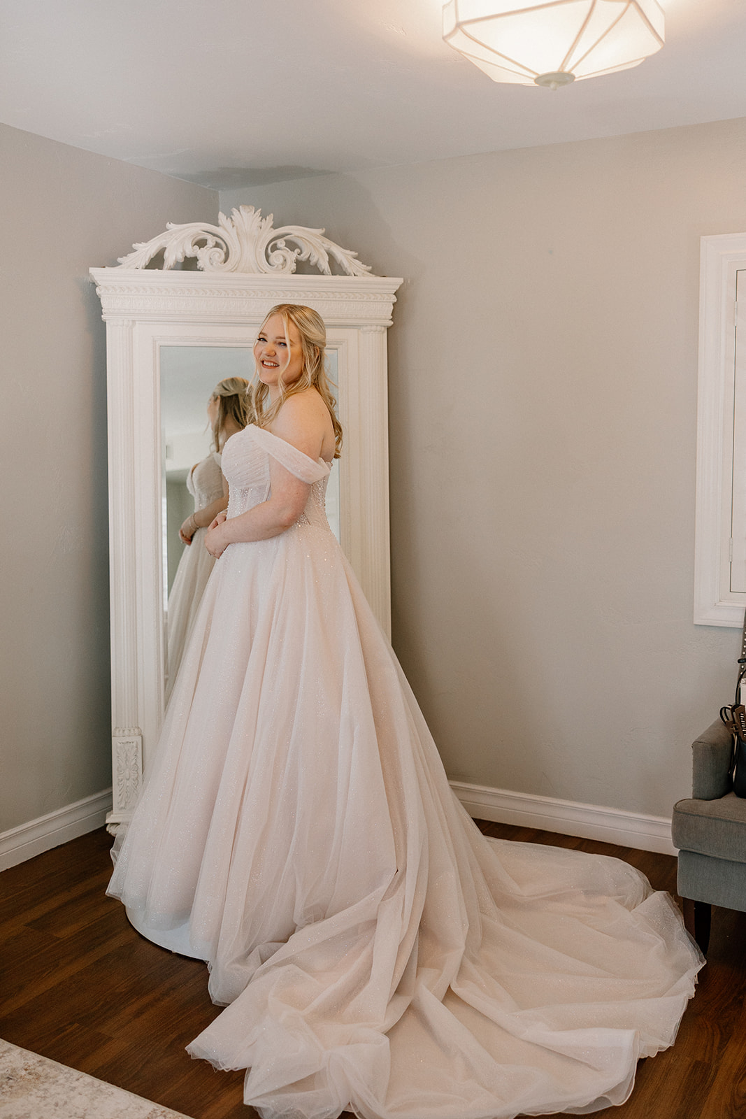Bride standing in bridal suite mirror before ceremony at Stonebridge Manor Wedding Venue