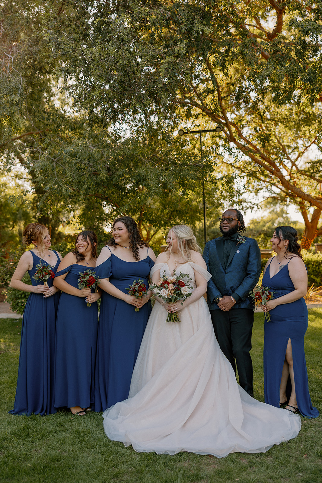Bridesmaids and groom laughing together during wedding portraits at Stonebridge Manor Wedding Venue