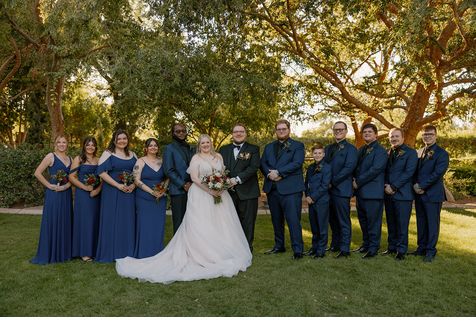 Full wedding party portrait on the green lawn at Stonebridge Manor Wedding Venue