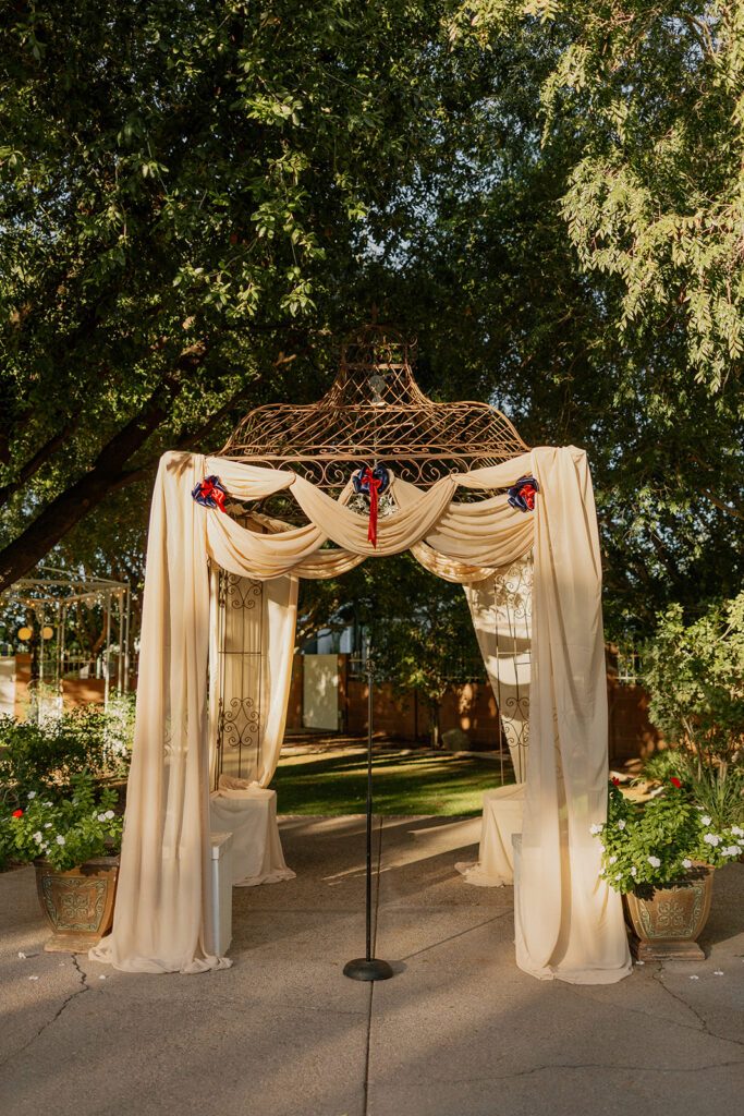 Outdoor ceremony arbor with drapery and greenery at Stonebridge Manor Wedding Venue