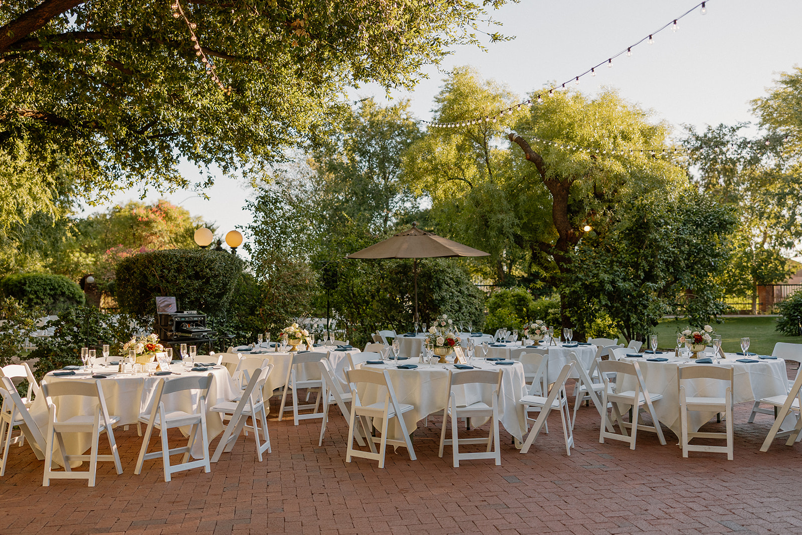 Outdoor reception patio setup with round tables and string lights at Stonebridge Manor Wedding Venue