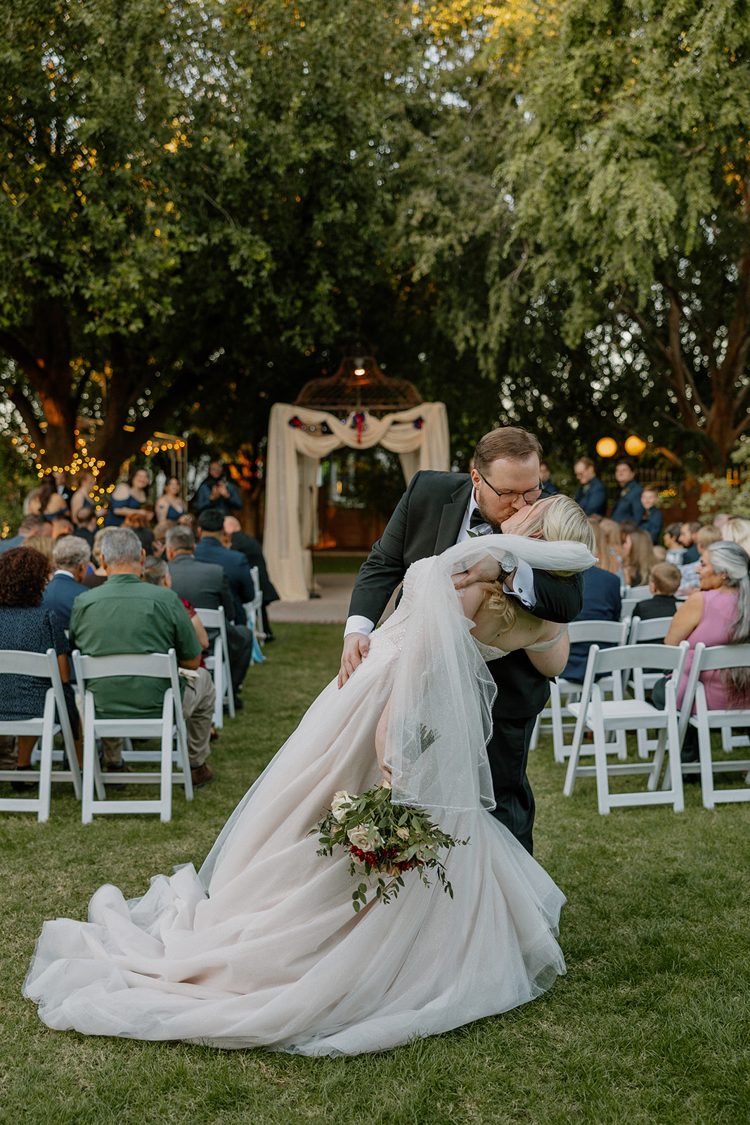 Groom dipping bride for a kiss after ceremony at Stonebridge Manor Wedding Venue