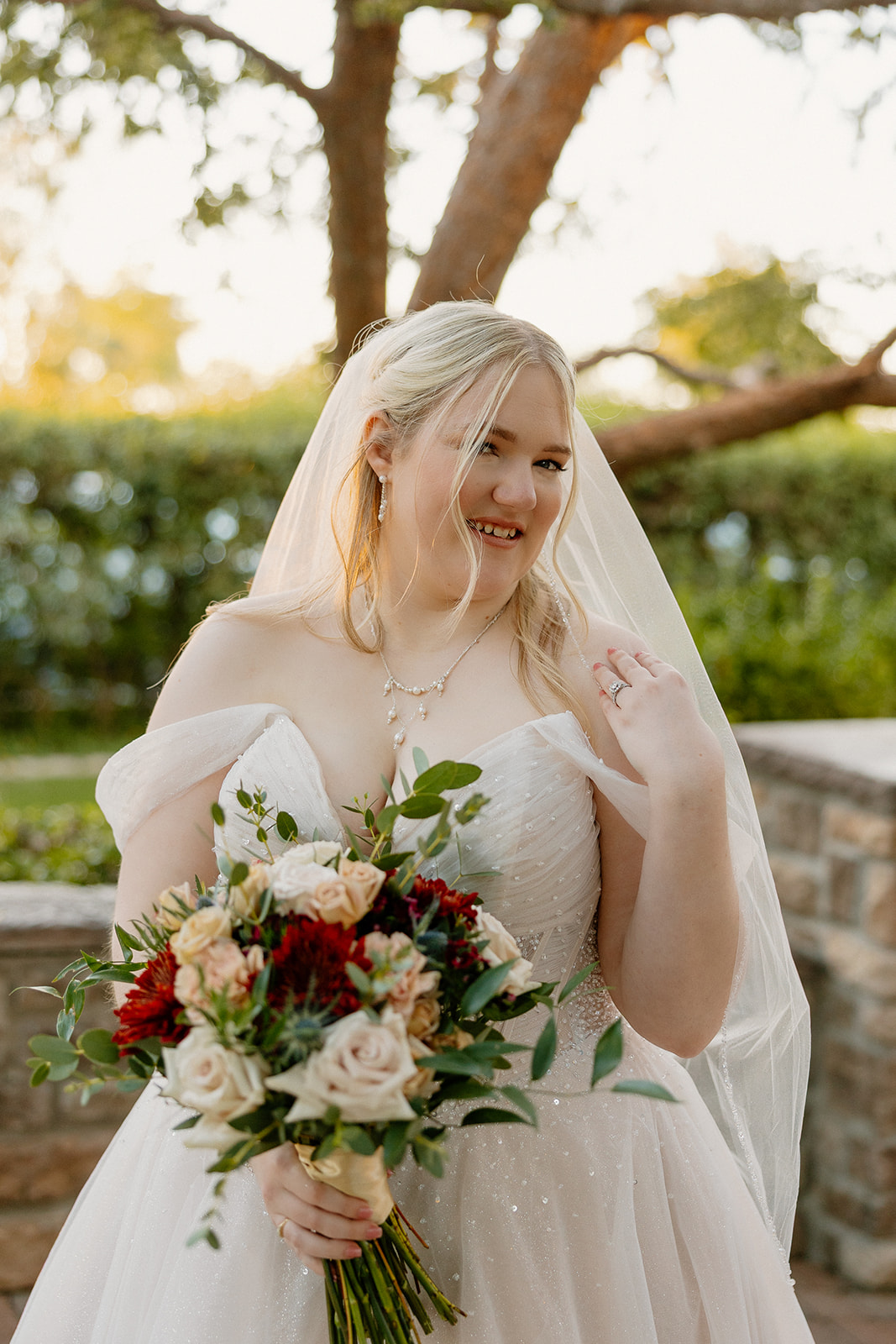 Bride holding bouquet during golden hour portraits at Stonebridge Manor Wedding Venue