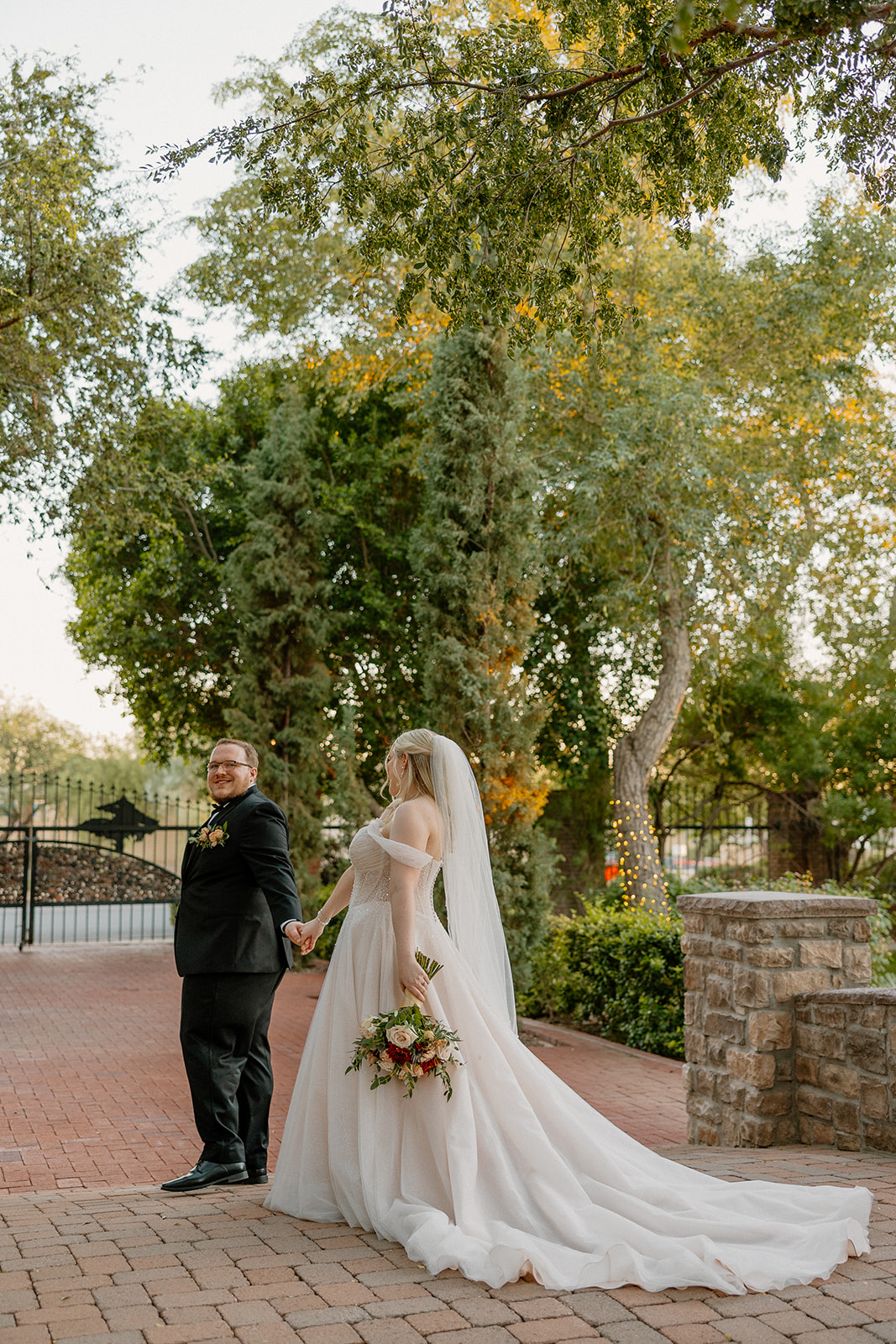 Bride and groom walking together on the brick pathway at Stonebridge Manor Wedding Venue