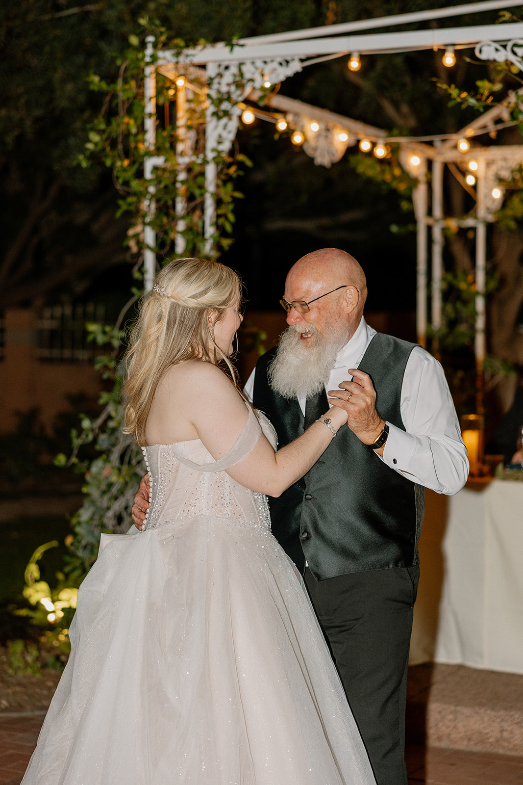 Bride dancing with father under string lights at Stonebridge Manor Wedding Venue reception