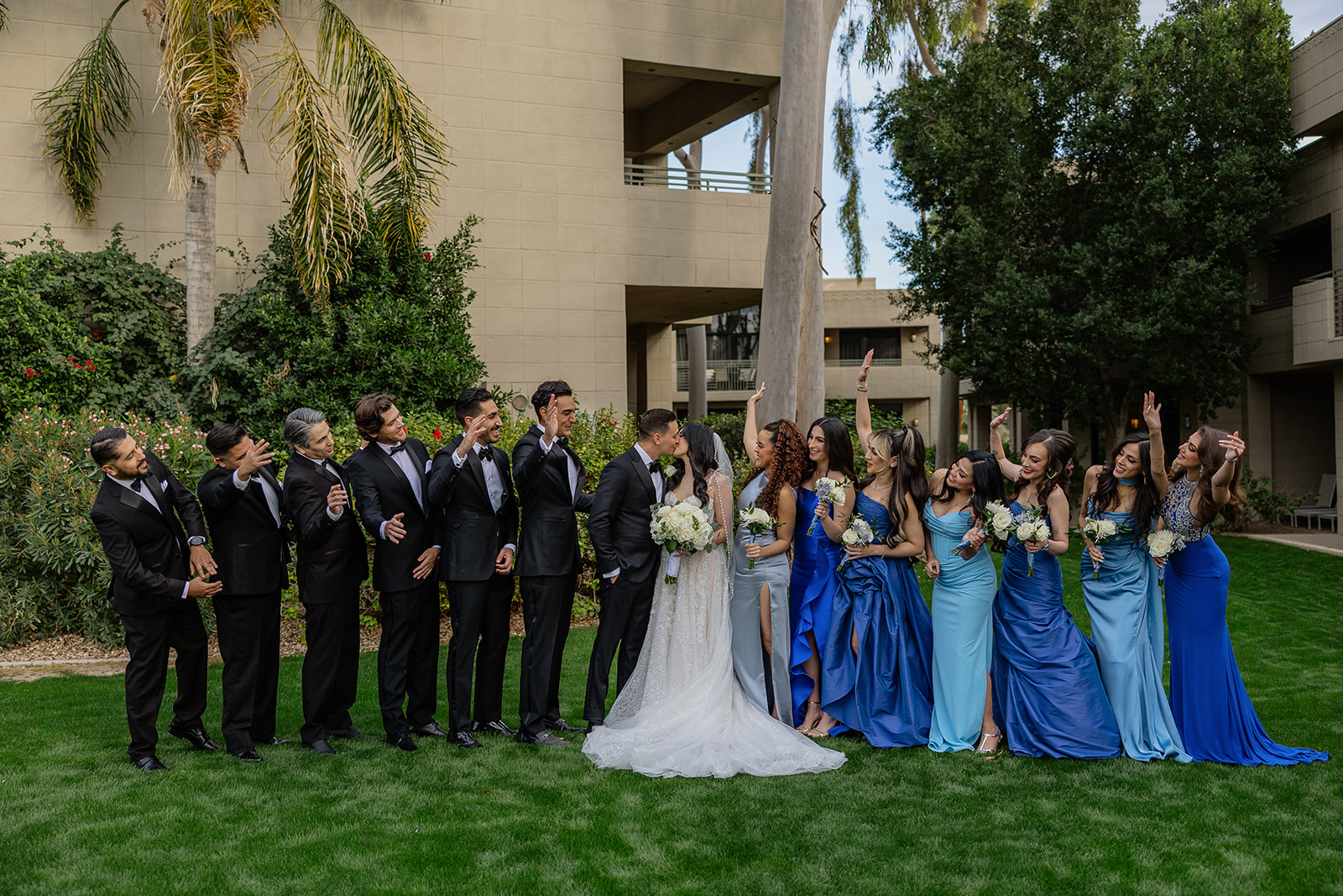 Full wedding party lined up on the lawn cheering and reacting around the couple during a Biltmore wedding
